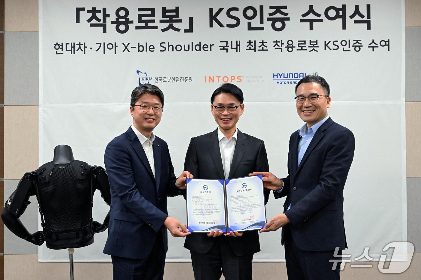 본문 이미지 - 엑스블 숄더 생산 업체인 인탑스 구미 공장에서 열린 KS 인증 수여식에서 (좌측부터) 한국로봇산업진흥원 김태우 본부장, 인탑스 김근하 대표, 현대차·기아 로보틱스랩 최리군 상무가 기념 사진을 촬영하고 있다. (현대차그룹 제공)