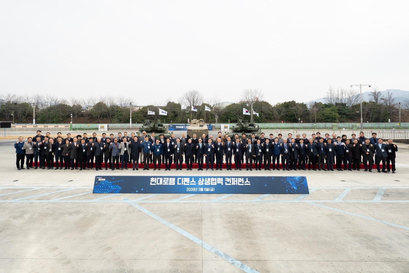 본문 이미지 - 국회와 67개 협력사, 현대로템 등 관계자들이 지난 6일 경남 창원특례시 현대로템 창원공장에서 열린 '2026 현대로템 디펜스 상생협력 컨퍼런스'에서 기념촬영을 하고 있다. (현대로템 제공)