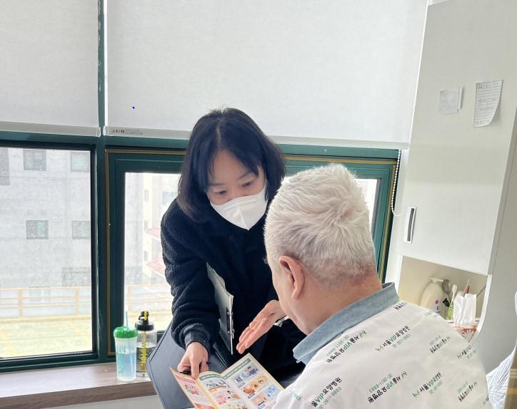 본문 이미지 - 의료급여 사례관리자가 입원 중인 수급자에게 맞춤형 복지 서비스를 안내하고 있다.