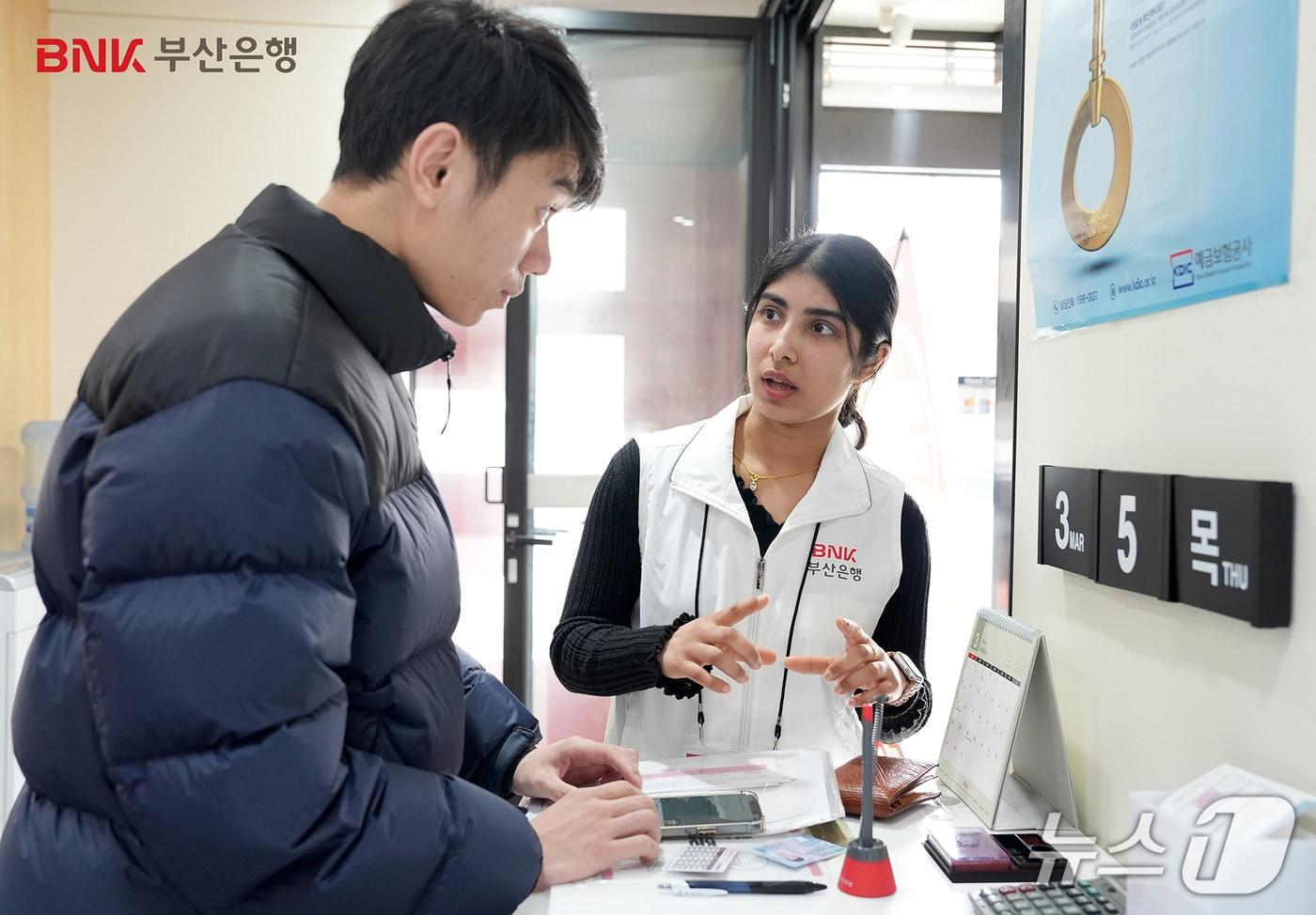 본문 이미지 - 현장에 배치된 부산은행 외국인 서포터즈가 은행을 방문한 외국인에게 금융 서비스에 대해 안내하고 있는 모습 (부산은행 제공. 재판매 및 DB금지)