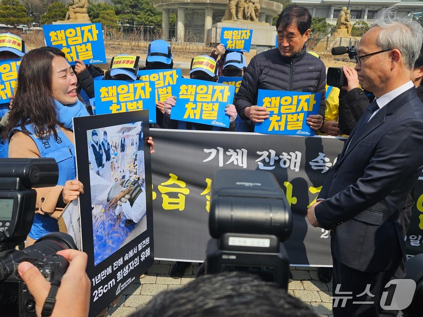 본문 이미지 - 12·29 무안공항 제주항공 여객기 참사 유가족이 9일 오전 서울 종로구 청와대 인근에서 기자회견 후 주진우 대통령실 공공갈등조정비서관에게 항의 서한을 전달 중인 모습. 2026.3.9 ⓒ 뉴스1 유채연 기자