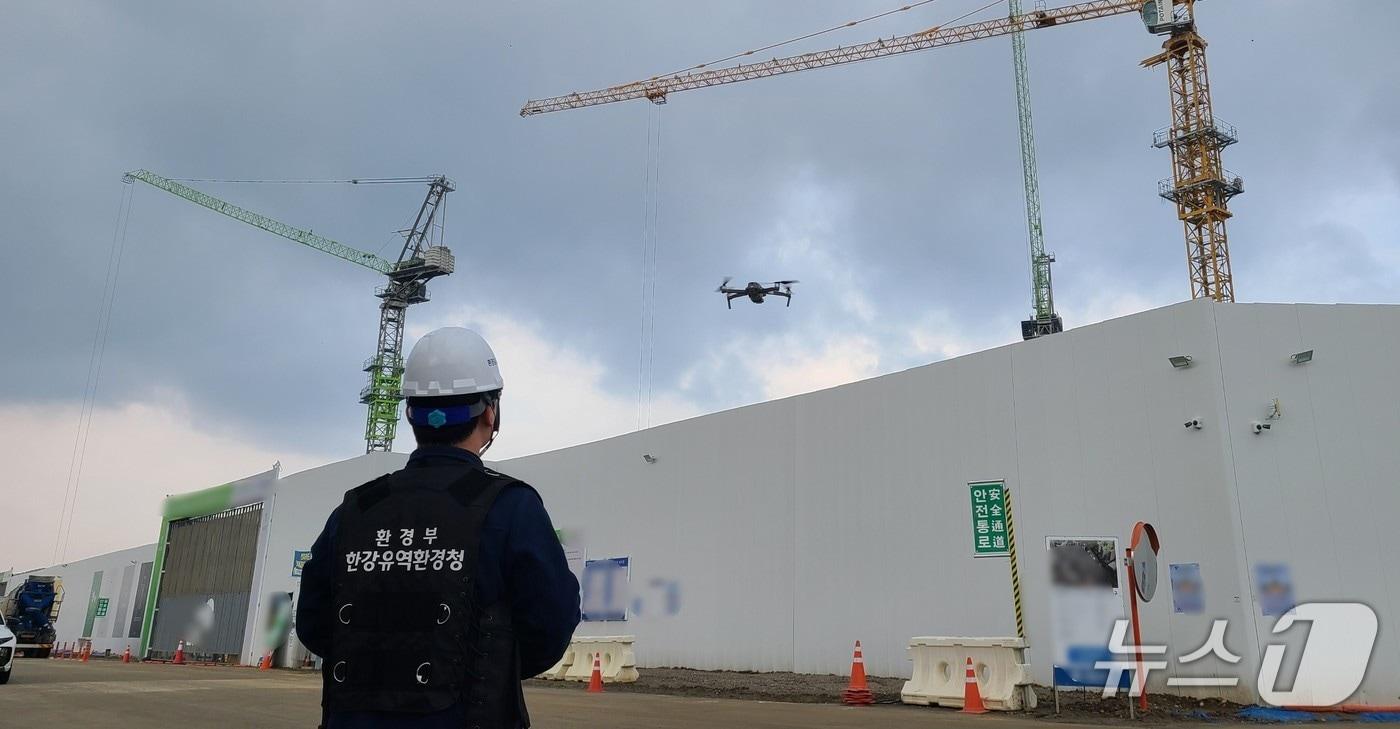 본문 이미지 - 한강청 환경감시단원이 지난 6일 경기 남양주시의 한 공사현장에서 드론으로 방진덮개 설치 여부 등을 확인하고 있다.(한강청 제공)
