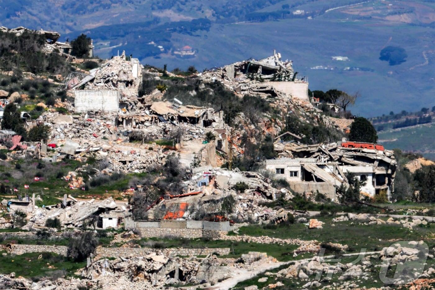 본문 이미지 -  8일(현지시간) 이스라엘 북부 국경 너머에서 바라본 레바논 남부 도시 크파르 킬라의 파괴된 건물의 모습 2026.03.08. ⓒ AFP=뉴스1