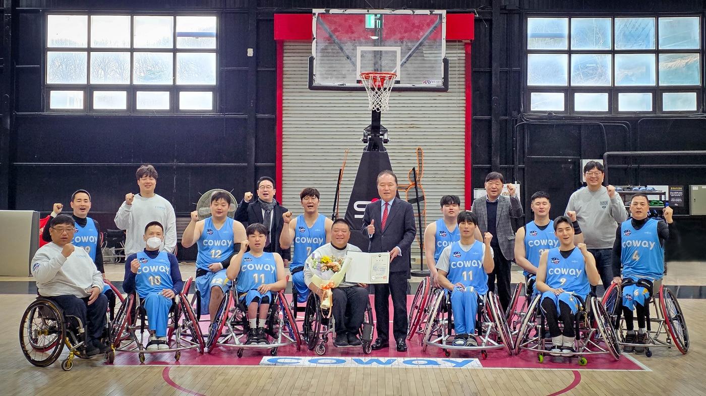 본문 이미지 - 안병태 총재와 김영무 감독, 코웨이 블루휠스 선수들이 함께 기념사진을 촬영하고 있다.(코웨이 제공)