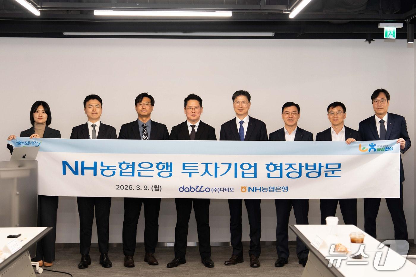 본문 이미지 - 9일 강태영 NH농협은행 은행장(왼쪽에서 5번째)과 (주)다비오 박주흠 대표(왼쪽에서 4번째) 및 양사 임직원들이 기념사진 촬영을 하고 있다. 26.03.09 / 사진제공=농협은행