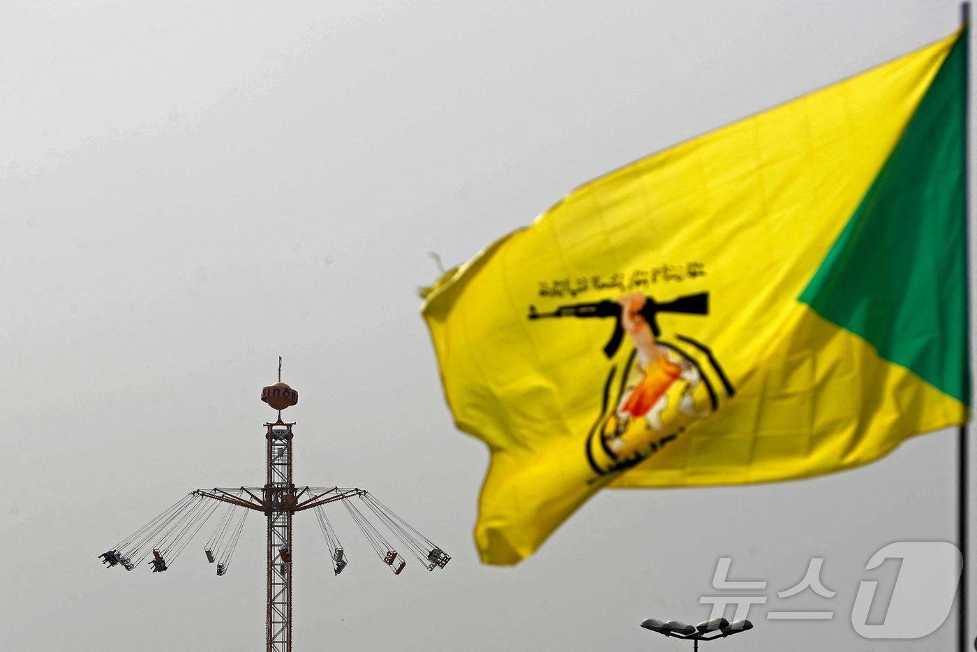 본문 이미지 - 21일(현지시간) 이라크 바그다드에서 친(親)이란 시아파 무장단체 카타이브 헤즈볼라 깃발이 펄럭이고 있다. 2026.03.21. ⓒ AFP=뉴스1