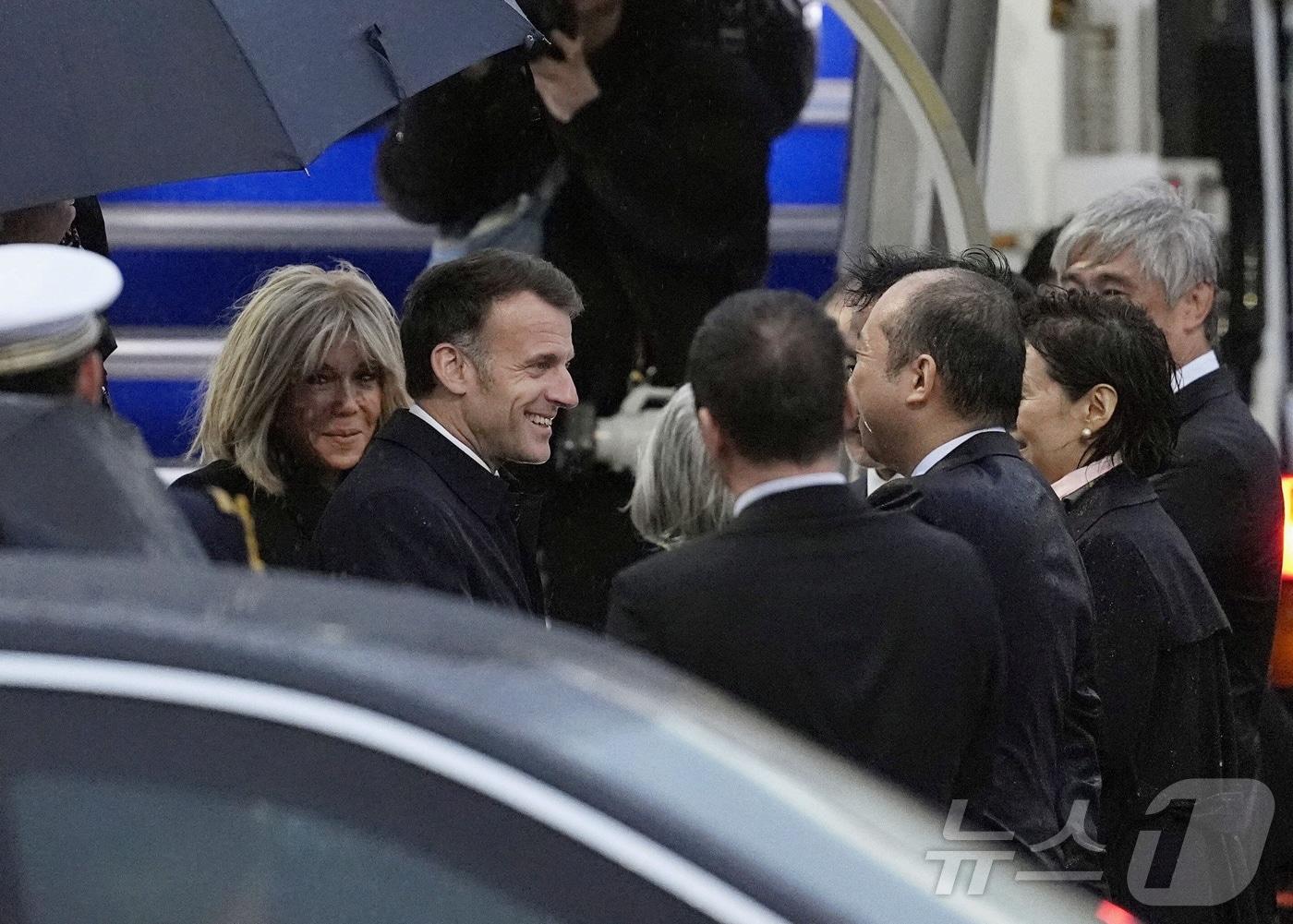 본문 이미지 - 에마뉘엘 마크롱(가운데) 프랑스 대통령과 부인 브리지트 여사가 31일 일본 도쿄의 하네다 국제공항에 도착해 일본 측 관계자들과 환영 인사를 나누고 있다.(교도통신 제공) ⓒ 로이터=뉴스1