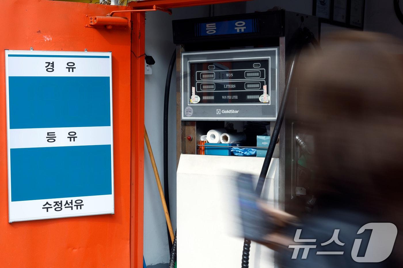 본문 이미지 - 중동 사태로 인해 유가가 급등하고 있는 1일 서울시 동대문구의 한 석유집의 꺼져 있는 주유기 앞으로 시민이 지고 있다. 경유와 등유 등을 소매하고 있는 석유집 주인은 높아진 매입가에 단골 손님에게 조차 판매를 할 수 없어 개점휴업 상태라며, 주유기를 꺼놓고 폐업을 해야할 지 고민이라고 고유가 상황에 대한 어려움을 토로했다. 2026.4.1 ⓒ 뉴스1 박정호 기자