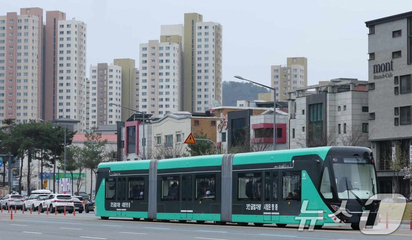 본문 이미지 - 1일 대전 서구 도안동 호수공원 일원에서 전국 최초 도입을 앞둔 3칸 굴절차량이 시범운행을 하고 있다. 3칸 굴절차량은 넓은 실내 공간과 최대 230명까지 수송이 가능한 대용량 교통수단으로, 혼잡한 출퇴근 시간대에도 쾌적한 대중교통환경을 제공할 수 있다. 또한 저상형 구조로 설계돼 노약자와 어린이 등 교통약자도 편리하게 이용할 수 있는 것이 특징이다. 시는 전용차로 및 차고지 등 기반 시설 구축 일정에 맞춰 올해 10월까지 단계적으로 개통할 계획이다. 2026.4.1 ⓒ 뉴스1 김기태 기자