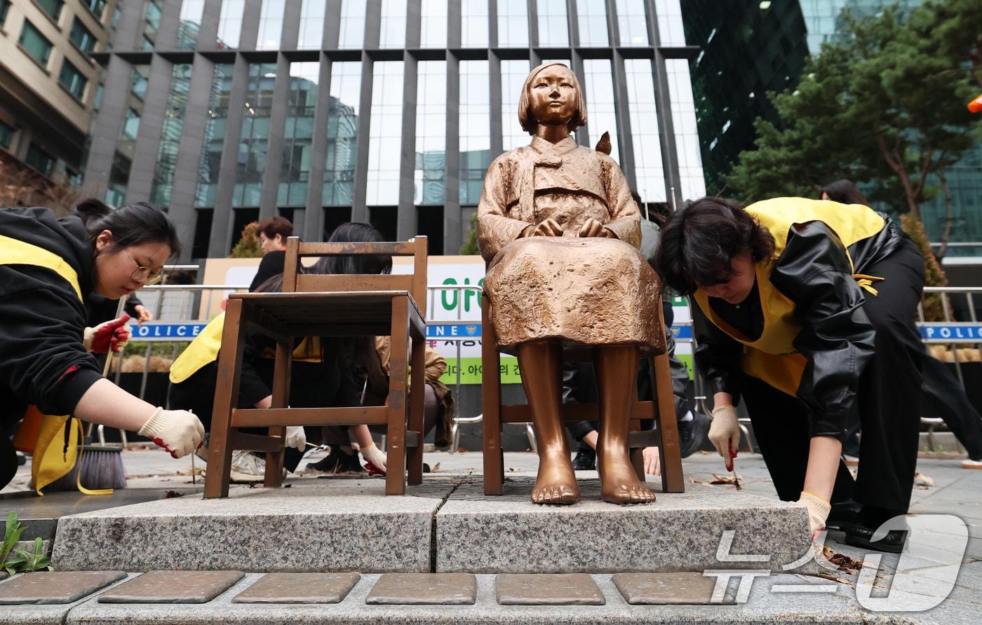 본문 이미지 - 1일 서울 종로구 옛 주한 일본대사관 앞에서 열린 제1746차 일본군 성노예제 문제해결을 위한 정기 수요시위에 앞서 정의기억연대 관계자들이 6년 여 만에 바리케이드가 철거된 평화의 소녀상의 묵은 때를 벗기고 있다. 정의기억연대는 지난 6년여 간 맞불 집회를 열어온 김병헌 위안부법폐지국민행동 대표가 사자명예훼손 등 혐의로 구속되고 관련 단체들의 집회가 취소되자 소녀상 보호를 위해 설치된 바리케이드 철거를 추진해 왔다. 2026.4.1 ⓒ 뉴스1 오대일 기자