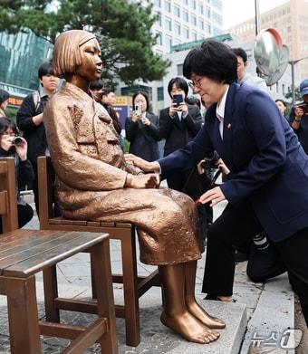 본문 이미지 - 원민경 성평등가족부 장관이 1일 서울 종로구 옛 주한 일본대사관 앞 수요시위 현장을 깜짝 방문, 6년 여 만에 바리케이드가 철거된 평화의 소녀상의 묵은 때를 벗기고 있다. 정의기억연대는 지난 6년여 간 맞불 집회를 열어온 김병헌 위안부법폐지국민행동 대표가 사자명예훼손 등 혐의로 구속되고 관련 단체들의 집회가 취소되자 소녀상 보호를 위해 설치된 바리케이드 철거를 추진해 왔다. 2026.4.1 ⓒ 뉴스1 오대일 기자