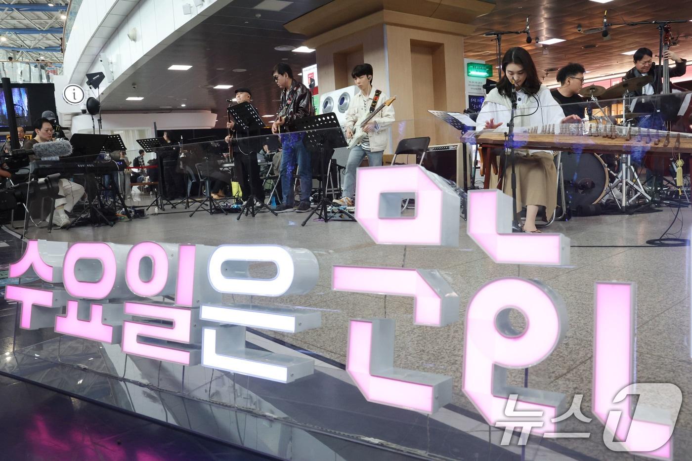 본문 이미지 - 최휘영 문화체육관광부 장관이 1일 오후 서울 중구 서울역에서 열린 '문화가 있는 날' 확대 기념 행사에서 기타를 연주하며 공연에 참여하고 있다. 2026.4.1 ⓒ 뉴스1 이광호 기자