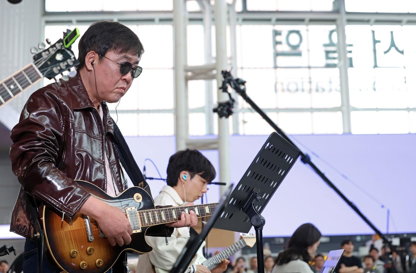 본문 이미지 - 최휘영 문화체육관광부 장관이 1일 서울역에서 열린 '수요일은 문화요일, 문화로 놀자!'에서 기타를 연주하고 있다.
