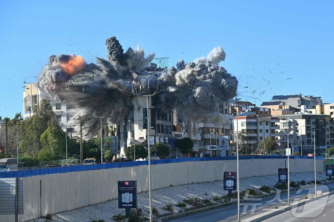 본문 이미지 - 31일(현지시간) 레바논 베이루트 국제공항으로 이어지는 고속도로 인근 건물에서 이스라엘의 공습으로 화염이 치솟고 있다. 2026.03.31. ⓒ AFP=뉴스1