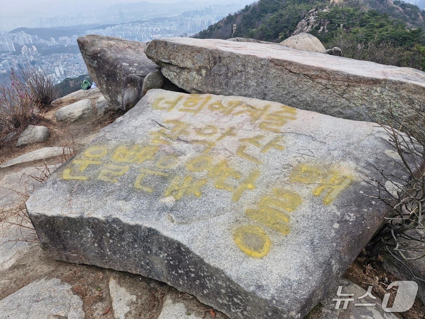 본문 이미지 - 래커 낙서로 훼손된 관악산 마당바위의 모습. (사진. 관악구청 제공)