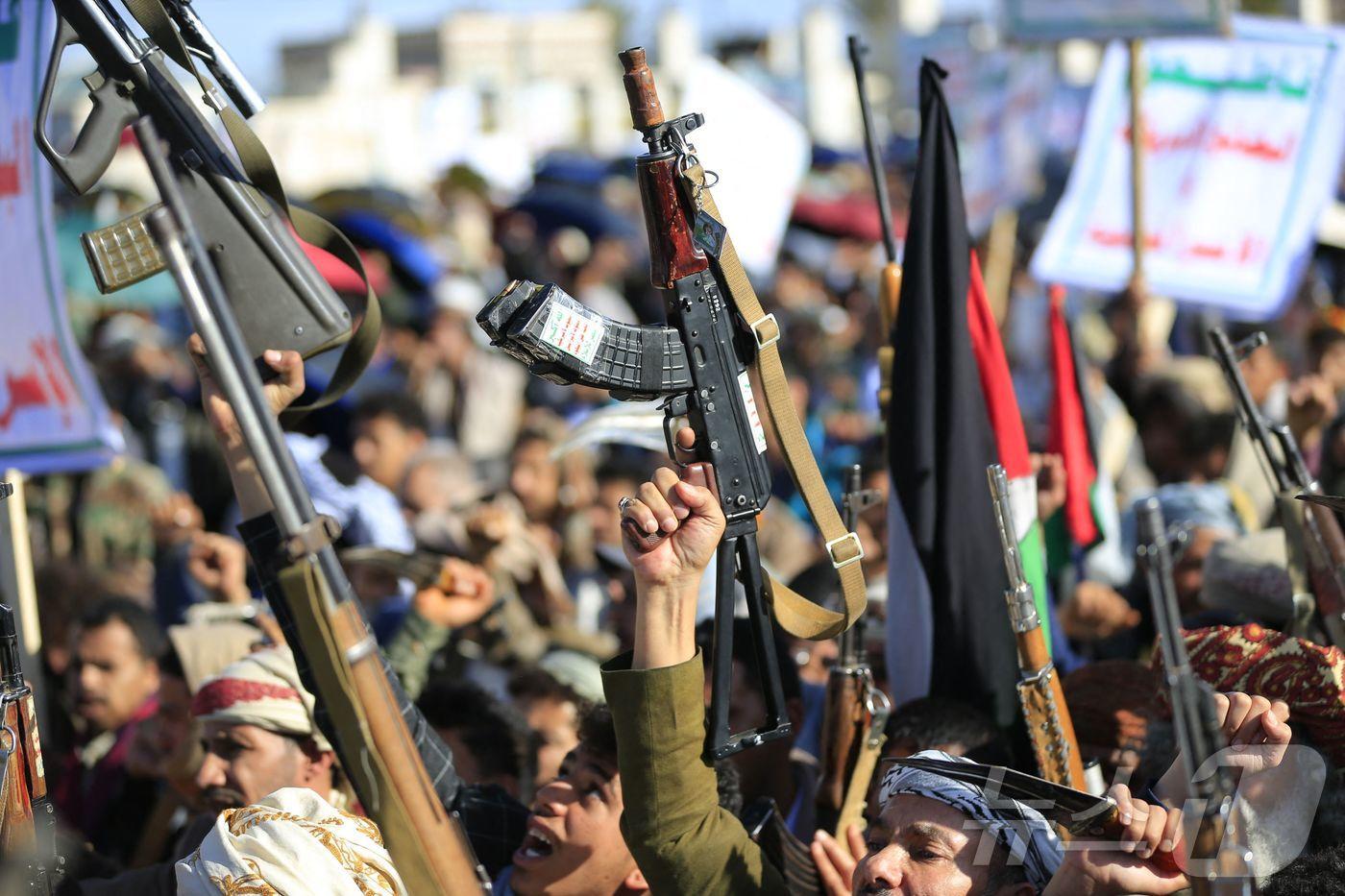 본문 이미지 - 예멘 수도 사나에서 열린 후티 반군 집회에서 참가자들이 이란과 헤즈볼라에 연대를 표명하며 무기를 들어보이고 있다. 2026.03.27 ⓒ AFP=뉴스1