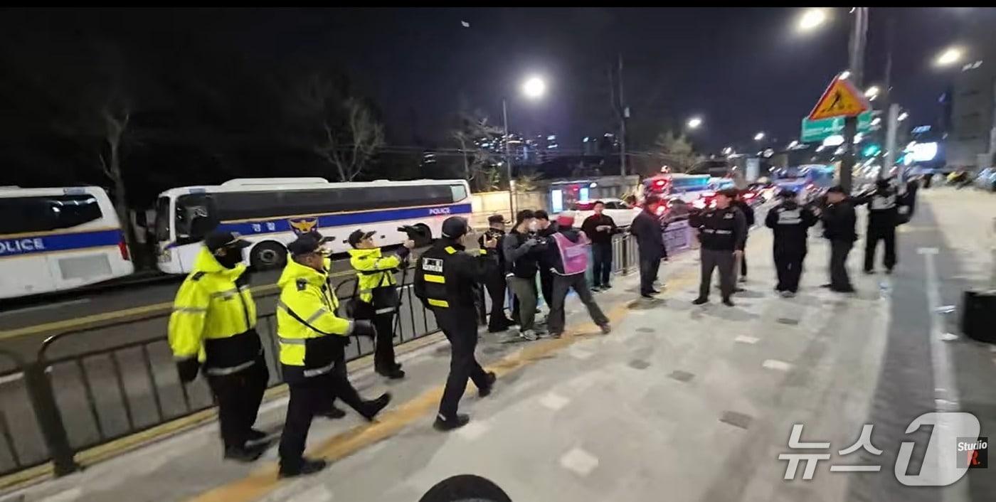 본문 이미지 - 1일 오후 8시 30분쯤 서울 용산구 서울시교육청 신청사 앞 부지에서 지혜복 교사의 복직 등을 요구하는 '부당전보대책위' 집회 인력과 용산경찰서 등 경찰 인력이 대치하는 상황.(스튜디오 알 유튜브 라이브 갈무리)/뉴스1