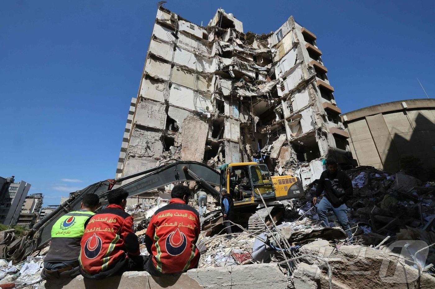 본문 이미지 - 9일(현지시간) 레바논 베이루트에서 구조대원들이 공습 현장의 잔해를 치우고 있다. 2026.4.10 ⓒ 뉴스1 ⓒ AFP=뉴스1