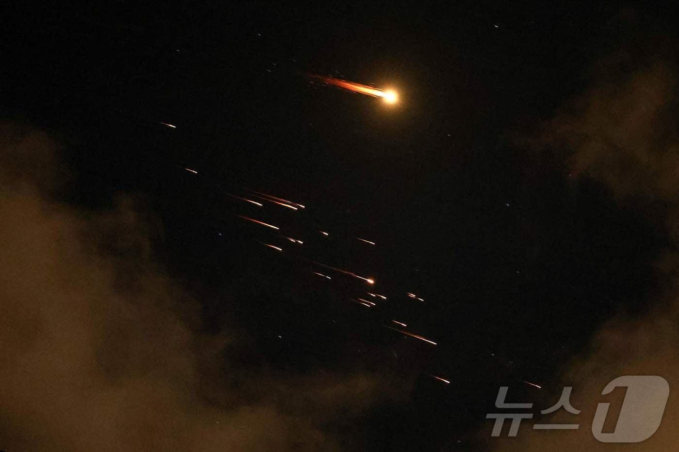본문 이미지 - 지난 8일(현지시간) 이스라엘 네타냐 상공에서 미사일 궤적이 포착됐다. 2026.04.08. ⓒ AFP=뉴스1