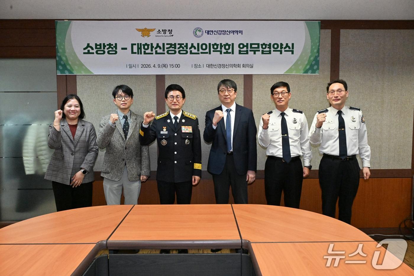 본문 이미지 - 9일 오후 대한신경정신의학회 회의실에서 열린 '소방청-대한신경정신의학회 업무협약식'에서 김승룡 소방청장과 최준호 이사장을 비롯한 양 기관 관계자들이 재난 현장에서 사투를 벌이는 소방관들의 심리적 회복을 위한 긴밀한 협력을 다짐하며 기념촬영을 하고 있다.(소방청 제공)