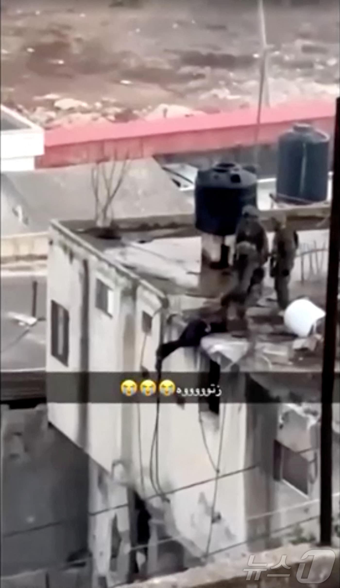 본문 이미지 - 지난 2024년 9월 19일(현지시간) 소셜미디어에 유포된 이스라엘군 병사들이 서안지구 카타비아에서 팔레스타인 전투원 시신을 한 건물 옥상에서 밀어서 떨어뜨리는 영상 갈무리. 2024.09.19 ⓒ 로이터=뉴스1