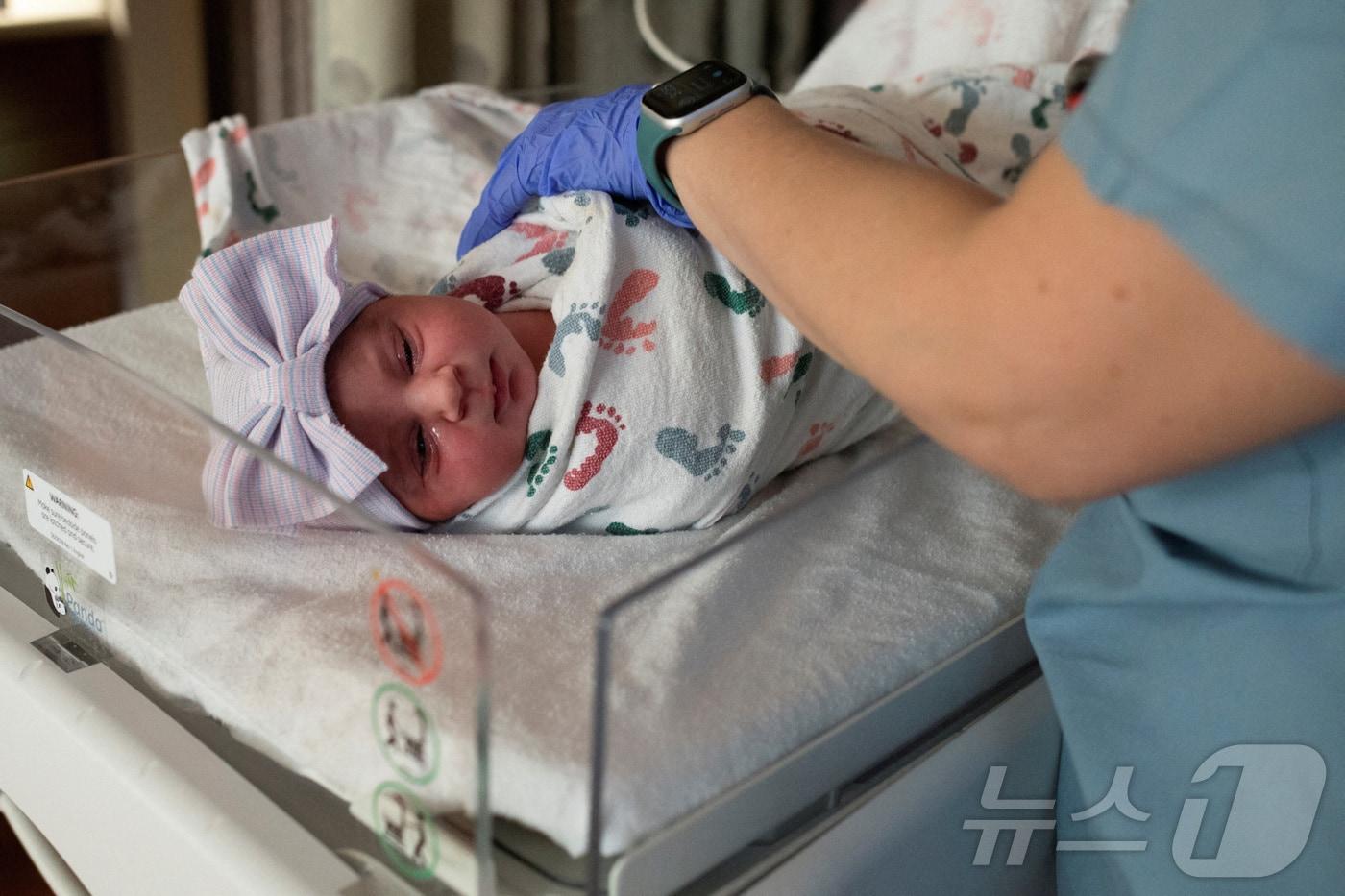 본문 이미지 - 2022년 2월 1일 미국 미시간주 로열오크 보몬트 병원 가족분만센터에서 한 간호사가 신생아의 활력징후를 확인하고 있다. 미 질병통제예방센터(CDC)에 따르면 2025년 미국의 출생아 수는 약 360만 명으로, 가임기 여성 1000명 당 약 53명 꼴로 사상 최저치를 경신했다. 2022.02.01. ⓒ 로이터=뉴스1