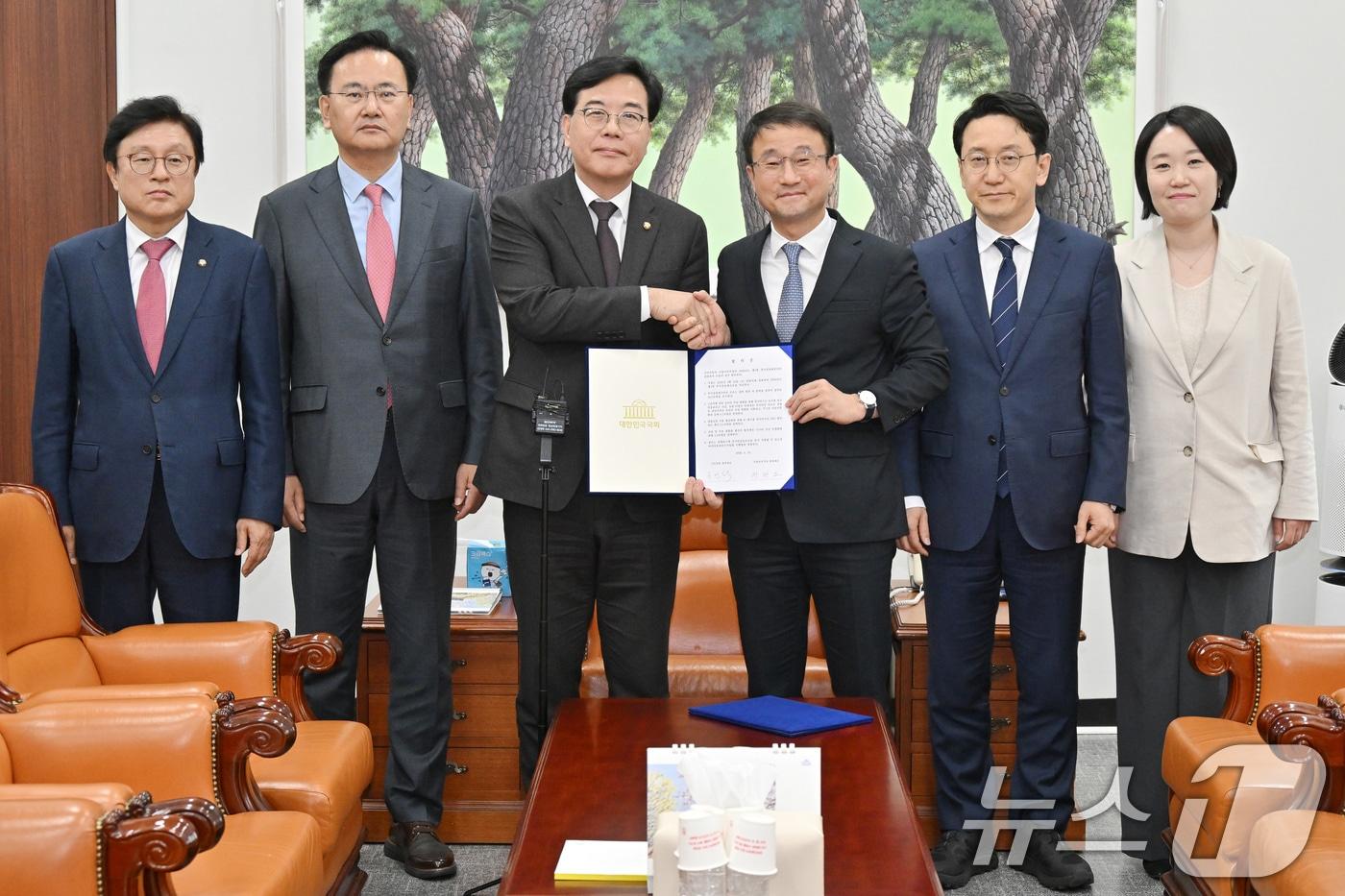 본문 이미지 - 더불어민주당 한병도, 국민의힘 송언석 원내대표와 여야 원내수석 및 예결위 간사들이 10일 서울 여의도 국회에서 2026년도 제1회 추가경정예산안 합의문을 들고 기념 촬영을 하고 있다. 왼쪽부터 국민의힘 박형수 예결위 간사, 유상범 원내운영수석부대표, 송 원내대표, 더불어민주당 한병도 원내대표, 천준호 원내운영수석부대표, 이소영 예결위 간사. (공동취재) 2026.4.10 ⓒ 뉴스1 신웅수 기자