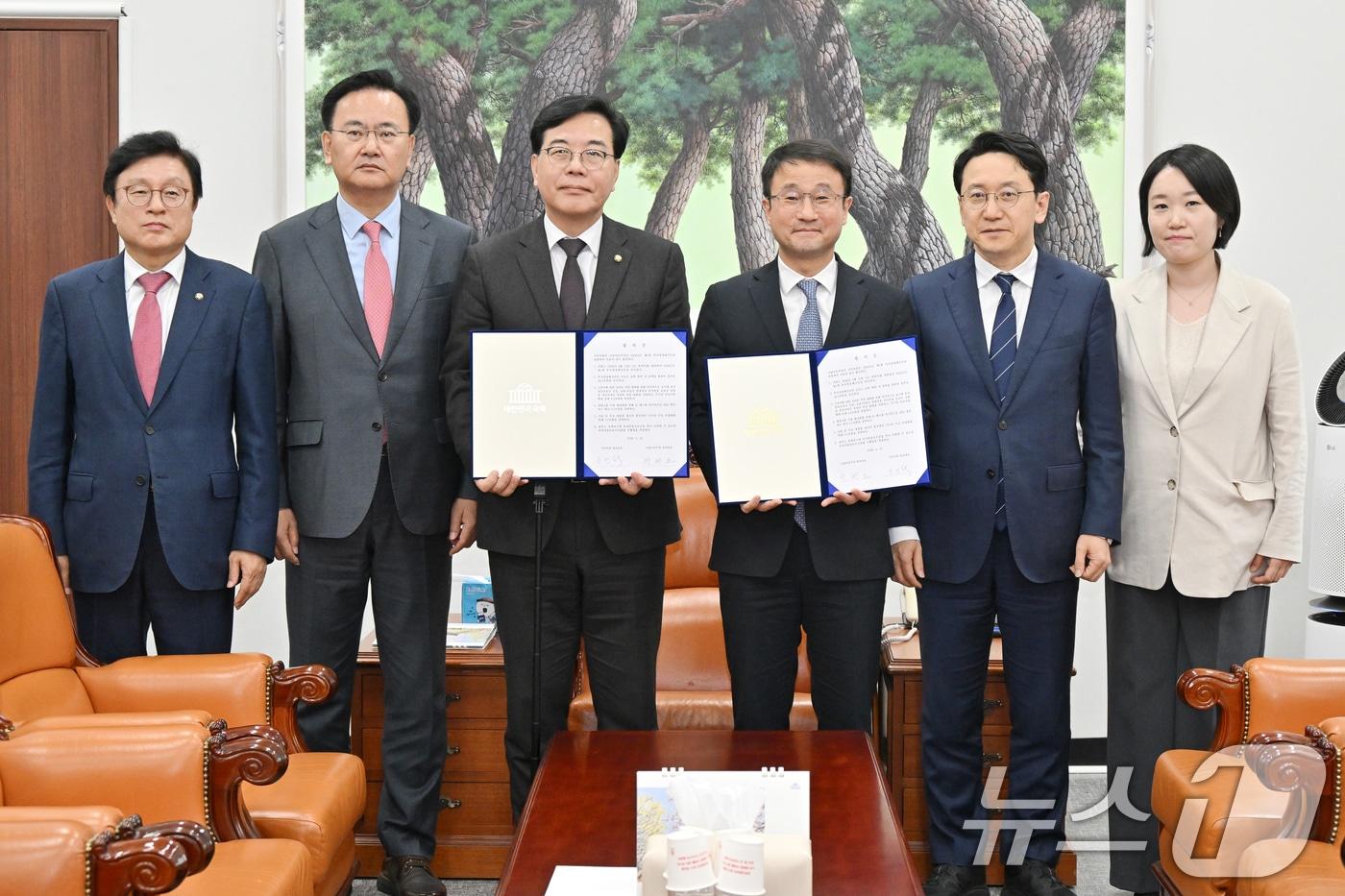 본문 이미지 - 더불어민주당 한병도, 국민의힘 송언석 원내대표와 여야 원내수석 및 예결위 간사들이 10일 서울 여의도 국회에서 2026년도 제1회 추가경정예산안 합의문을 들고 기념 촬영을 하고 있다. 왼쪽부터 국민의힘 박형수 예결위 간사, 유상범 원내운영수석부대표, 송 원내대표, 더불어민주당 한병도 원내대표, 천준호 원내운영수석부대표, 이소영 예결위 간사. (공동취재) 2026.4.10 ⓒ 뉴스1 신웅수 기자