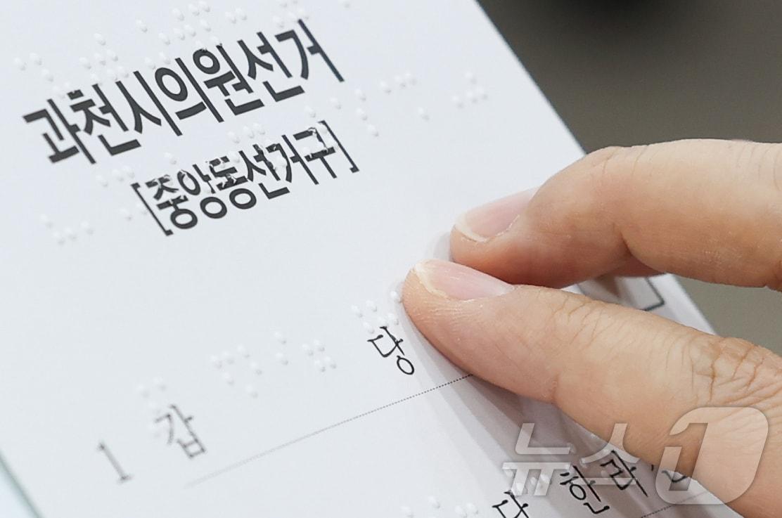 본문 이미지 - 10일 오후 서울 여의도 이룸센터에서 중앙선거관리위원회 주최로 열린 모의사전투표 체험에서 한 참석자가 점자로 된 투표용지를 읽고 있다. 2026.4.10 ⓒ 뉴스1 이종수 인턴기자