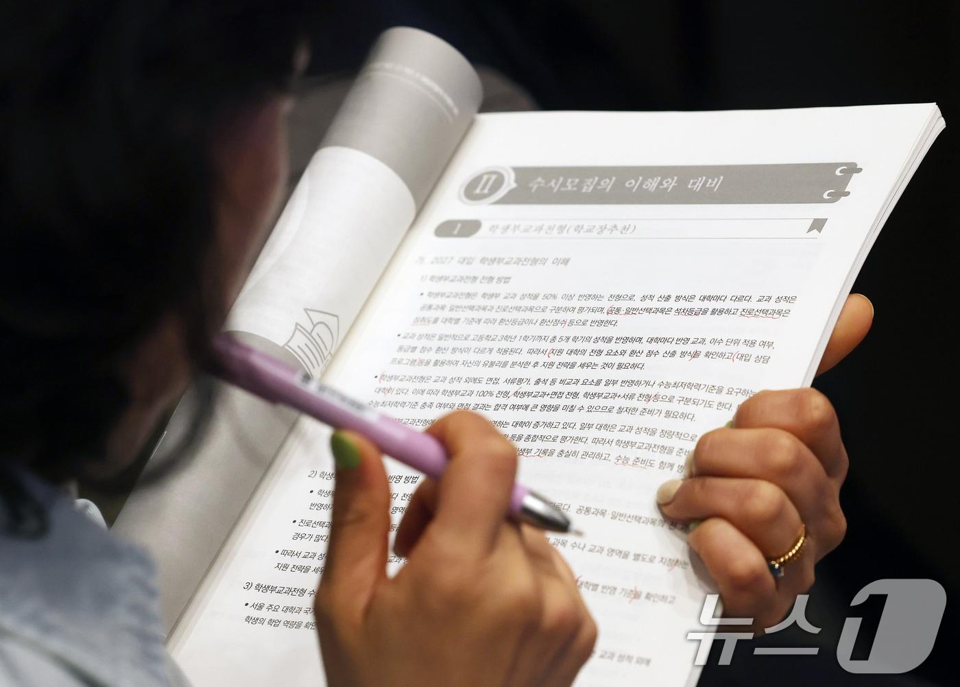 본문 이미지 - 12일 오후 서울 종로구 성균관대학교 600주년 기념관 새천년홀에서 열린 '초중고 의대 및 대입변화 특집 설명회'에서 한 학부모가 자료를 살펴보고 있다. 2026.4.12 ⓒ 뉴스1 오대일 기자