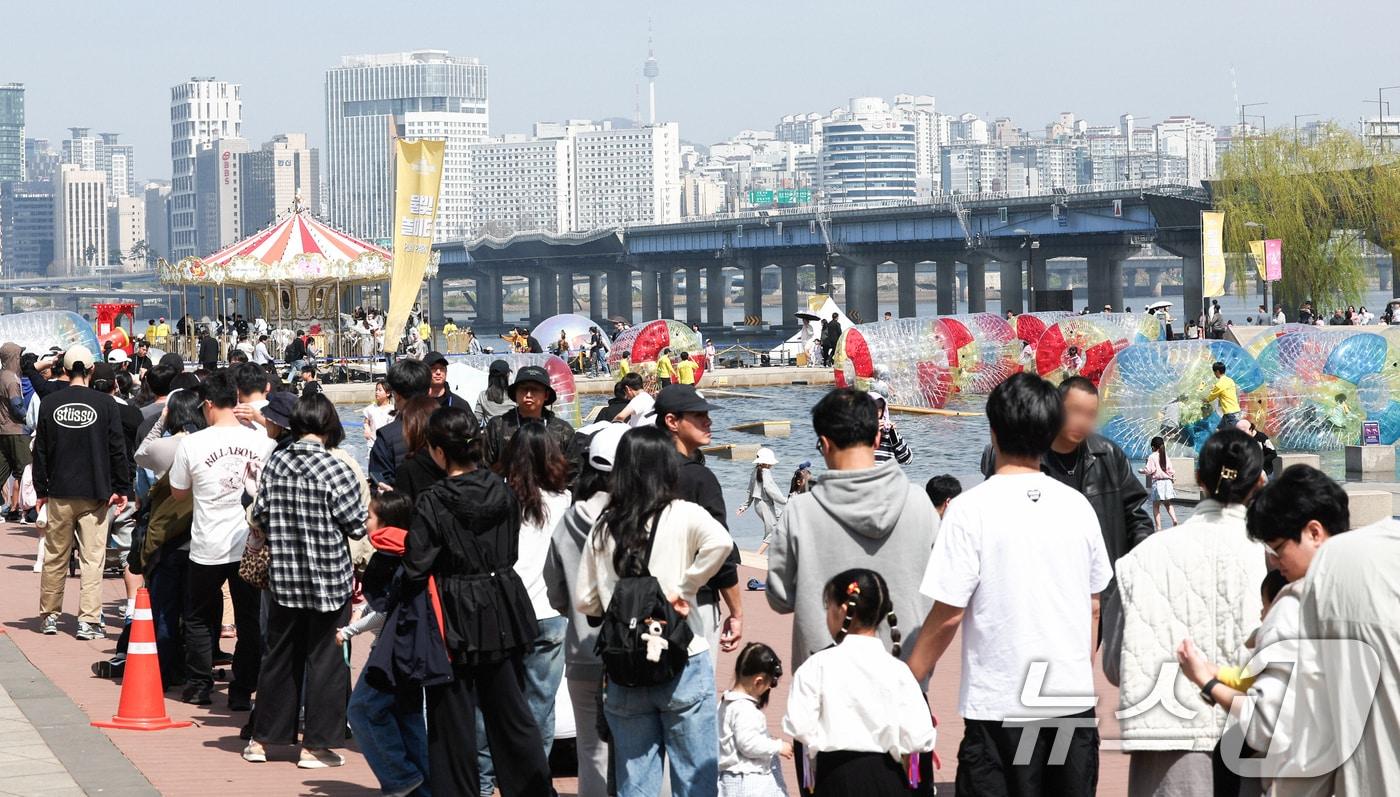 본문 이미지 - 12일 오후 서울 여의도 한강공원 물빛광장에서 열린 '서울스프링페스티벌'을 찾은 시민들이 다양한 프로그램을 체험하기 위해 줄을 서고 있다.2026.4.12 ⓒ 뉴스1 임지훈 인턴기자