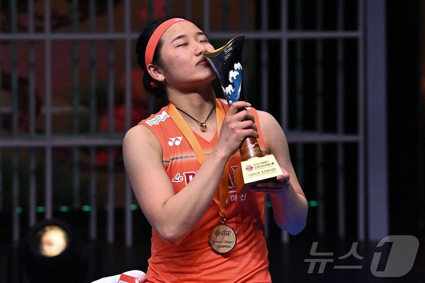 본문 이미지 - 12일(한국시간) 중국 닝보에서 열린 2026 아시아배드민턴선수권대회 여자 단식 결승전 왕즈이(중국)와의 경기에서 게임 스코어 2대1(21대12, 17대21, 21대18)로 꺾고 우승을 차지한 '배드민턴 여제' 안세영이 시상식에서 우승 트로피에 키스를 하고 있다. ⓒ AFP=뉴스1