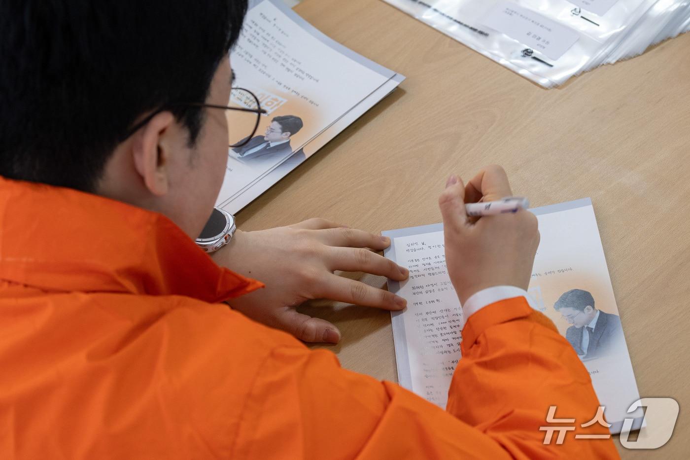본문 이미지 - 정이한 개혁신당 부산시장 후보가 공보물에 유권자 이름을 직접 적어 넣고 있다.(정이한 후보 측 제공. 재판매 및 DB금지)