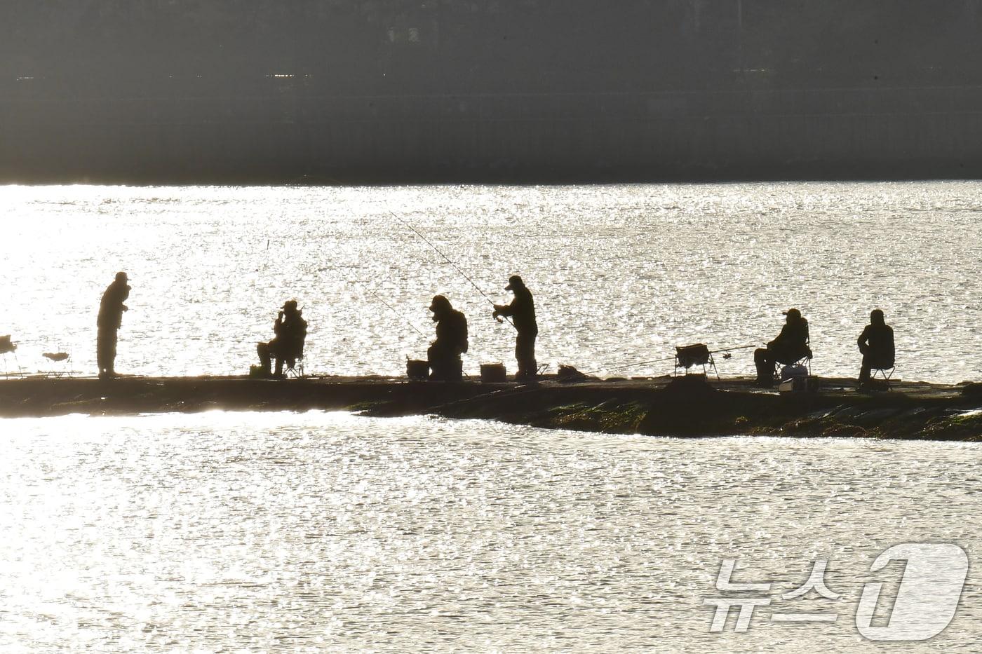 본문 이미지 - 13일 경북 포항시 송도해수욕장 방파제에서 강태공들이 아침 햇살을 받으며 낚시하고 있다. 2026.4.13 ⓒ 뉴스1 최창호 기자
