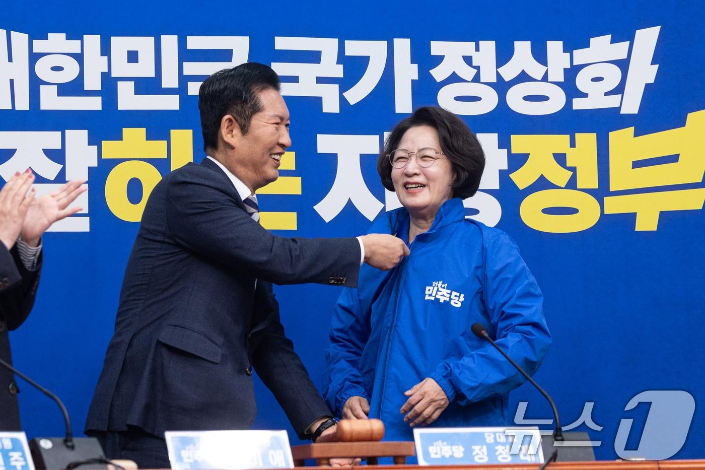 본문 이미지 - 정청래 더불어민주당 대표가 13일 서울 여의도 국회에서 열린 경기도지사 후보 환영식에서 추미애 후보에게 당 점퍼를 입혀주고 있다. 2026.4.13 ⓒ 뉴스1 이승배 기자