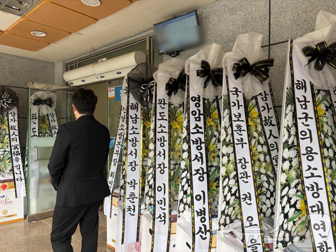 본문 이미지 - 13일 전남 완도군 완도읍 한 장례식장 앞에 냉동창고 화재를 진화하다 순직한 소방대원을 위한 근조화환이 놓여있는 모습. 2026.4.13 ⓒ 뉴스1 조수민 수습기자