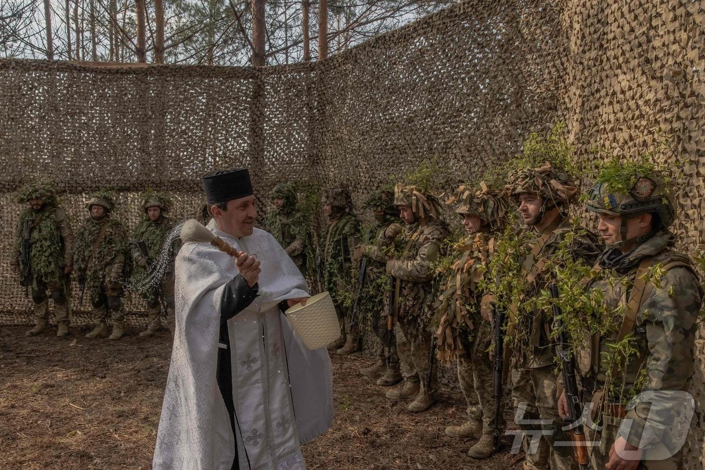 본문 이미지 - 12일(현지시간) 우크라이나 하르키우의 한 숲에서 우크라이나 군인들이 참석한 러시아 정교회 부활절 기념 야외 미사가 진행되고 있다. 2026.04.13. ⓒ AFP=뉴스1