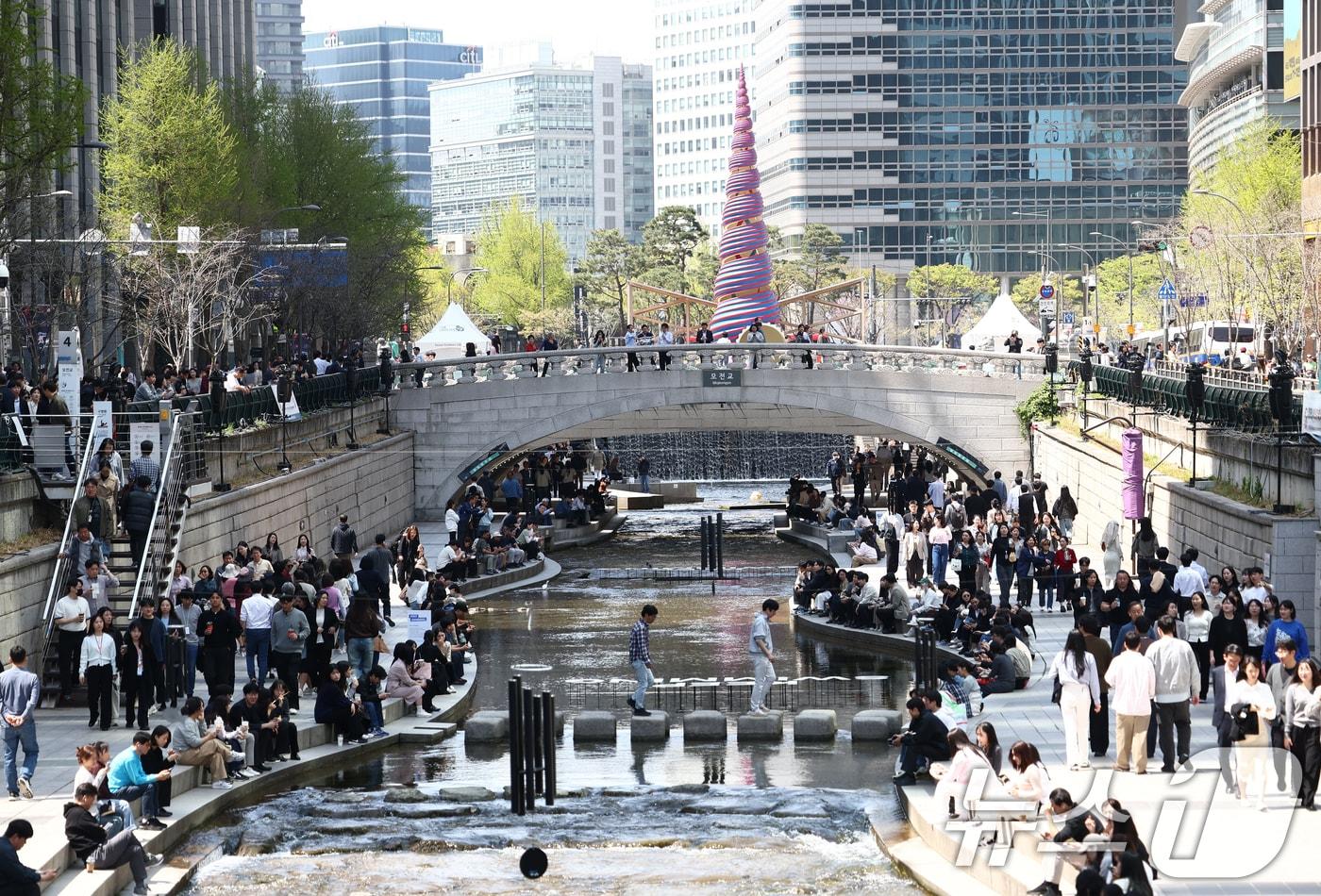 본문 이미지 - 서울 낮 최고 기온이 20도 중반 까지 오르는 등 초여름 날씨를 보인 13일 서울 청계천에서 시민들이 여유로운 시간을 보내고 있다. 2026.4.13 ⓒ 뉴스1 김민지 기자