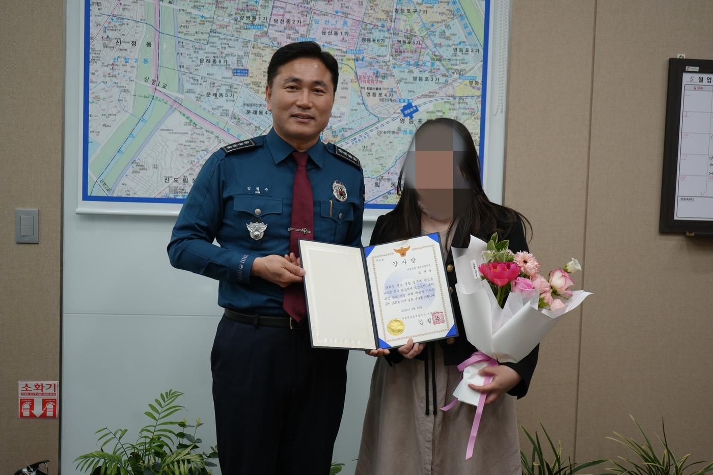 본문 이미지 - 김철수 서울영등포경찰서장(왼쪽)이 감사장을 받은 IBK기업은행 문래중앙지점 직원과 포즈를 취하고 있다.(서울 영등포경찰서 제공)