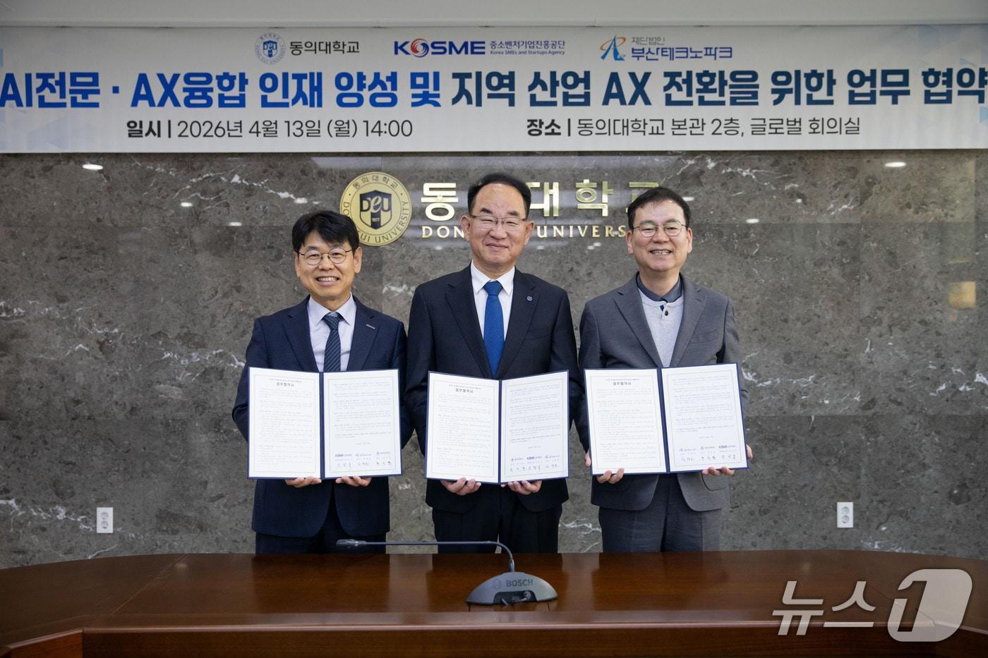 본문 이미지 - 13일 동의대학교 본관에서 열린 AI전문·AX융합 인재 양성 및 지역 산업 AX 전환을 위한 업무 협약식에서 반정식 중소벤처기업진흥공단 지역혁신이사(왼쪽부터), 한수환 동의대 총장, 김형균 부산테크노파크 원장이 협약서를 들어 보이고 있다. (동의대 제공. 재판매 및 DB 금지)