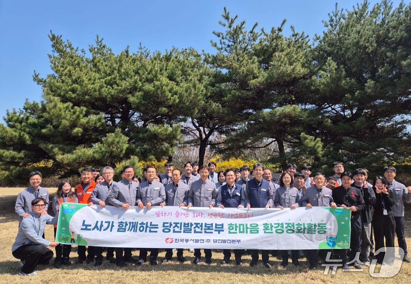 본문 이미지 - 13일 오전 당진시 교로3리 마을에서 석문각까지 노사합동 환경정화활동을 펼친 후 기념촬영을 하고 있다.(당진발전본부 제공. 재판매 및 DB금지)2026.4.13/뉴스1