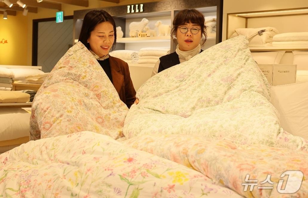 본문 이미지 - 롯데백화점 대구점 8층 침구 매장에서 고객이 가벼운 소재와 화사한 디자인의 봄 침구류를 살펴보고 있다.(롯데백화점 제공, 재판매 및 DB 금지)