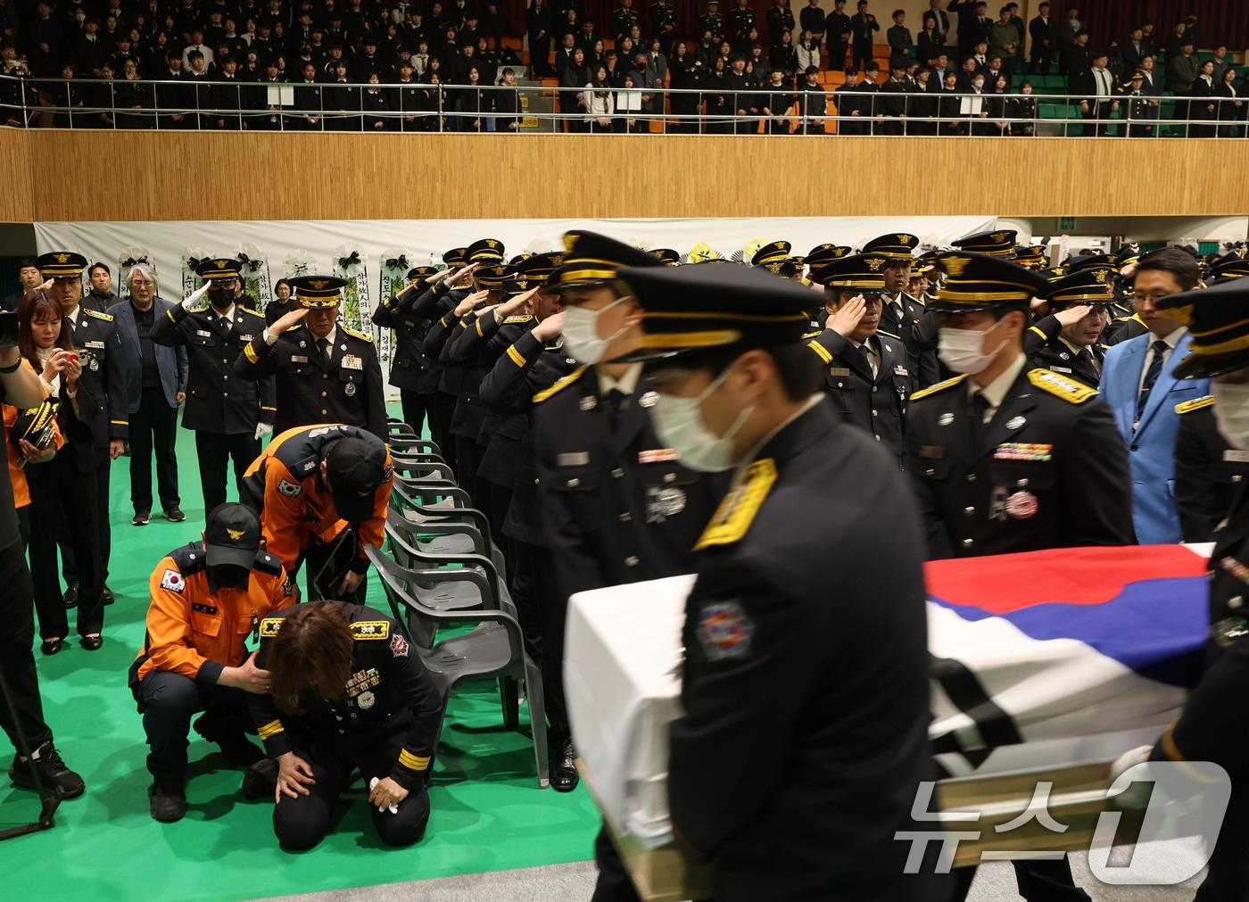 본문 이미지 - 냉동창고 화재를 진화하다 순직한 소방공무원 영결식이 진행된 14일 오전 전남 완도군농어민문화체육센터에서 운구가 진행되는 가운데 동료 소방공무원이 무릎 꿇고 오열하고 있다. 2026.4.14 ⓒ 뉴스1 박지현 기자