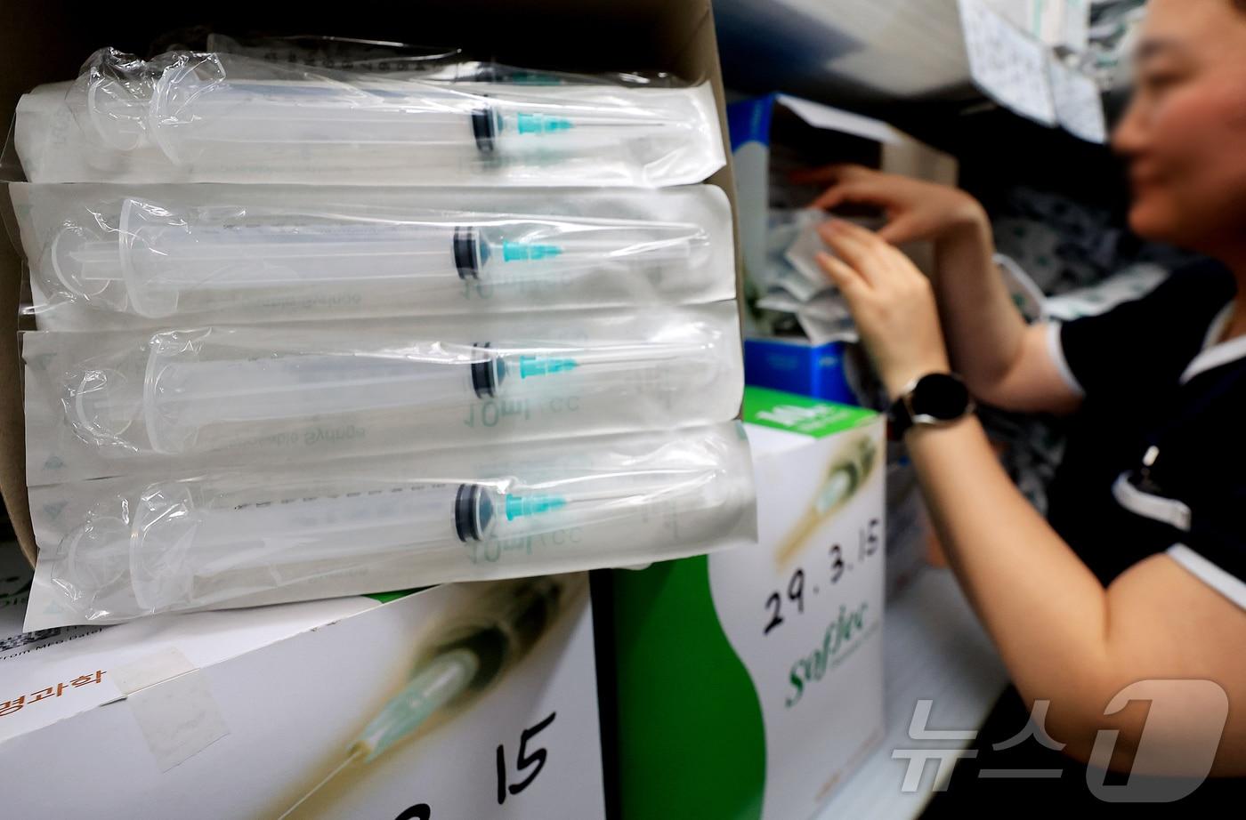 본문 이미지 - 중동 사태 장기화로 석유화학 원료 기반 의료 소모품의 수급 차질 우려가 커지자 정부가 주사기와 주사침에 대한 매점매석 행위를 금지하기로한 14일 서울의 한 병원에서 관계자가 주사기를 정리하고 있다.  2026.4.14 ⓒ 뉴스1 이호윤 기자