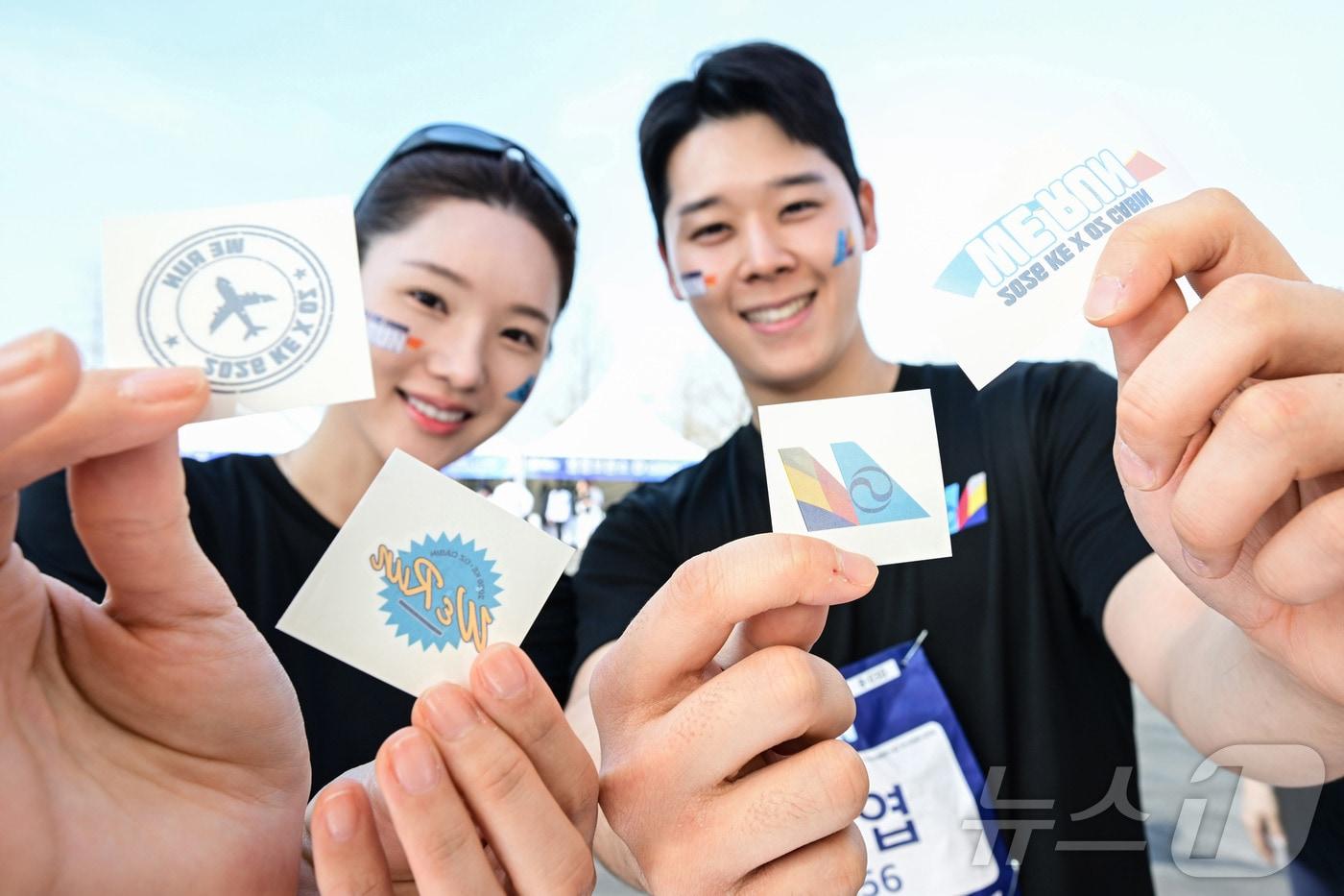 본문 이미지 - 14일 인천 중구 BMW 드라이빙센터에서 열린 대한항공·아시아나항공 객실승무원 화합 기부 러닝 행사 ‘WE RUN’에서 참여 승무원들이 타투 스티커 이벤트를 즐기고 있다. (공동취재) 2026.4.14 ⓒ 뉴스1 박지혜 기자