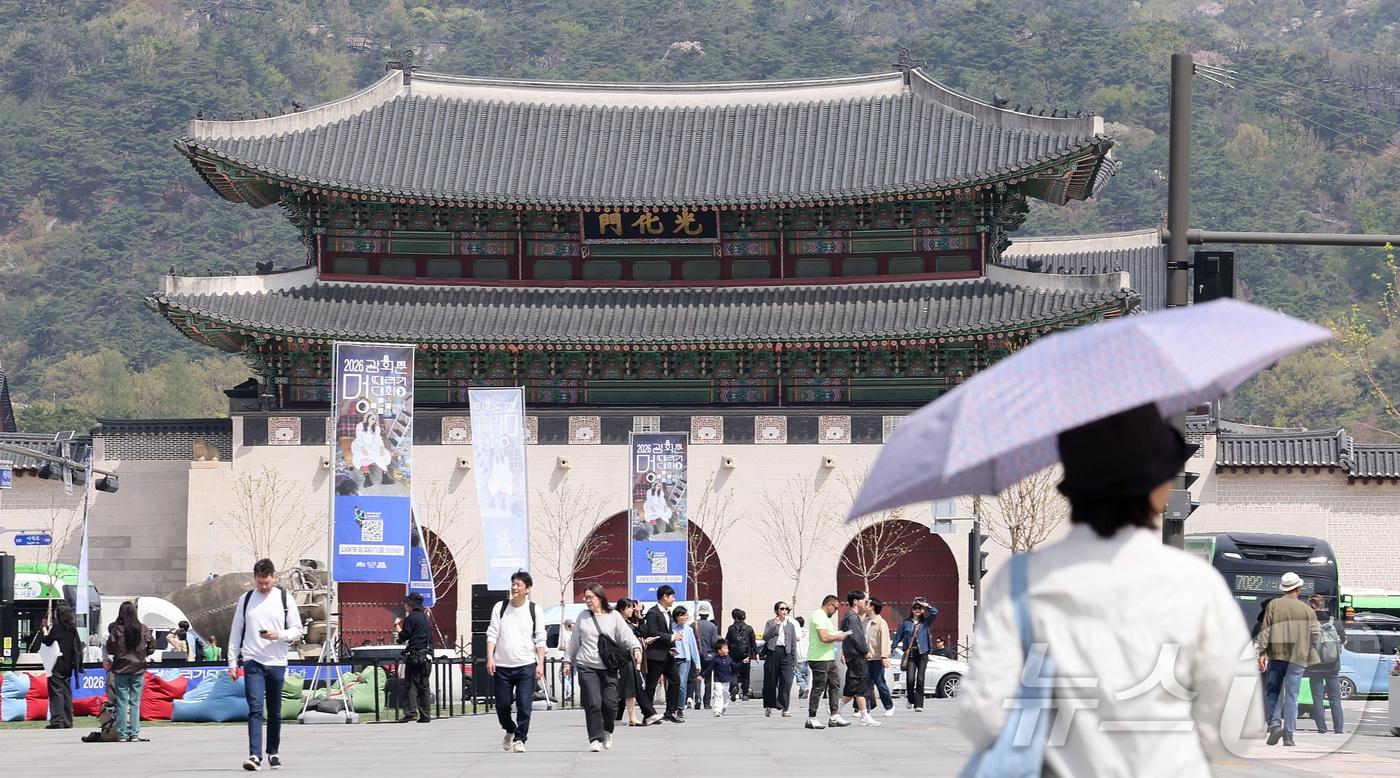 본문 이미지 - 서울 낮 최고 기온이 28도까지 오르는 등 초여름 날씨를 보인 14일 서울 종로구 광화문광장에서 한 시민이 양산을 쓰고 발걸음을 옮기고 있다. 2026.4.14 ⓒ 뉴스1 김성진 기자