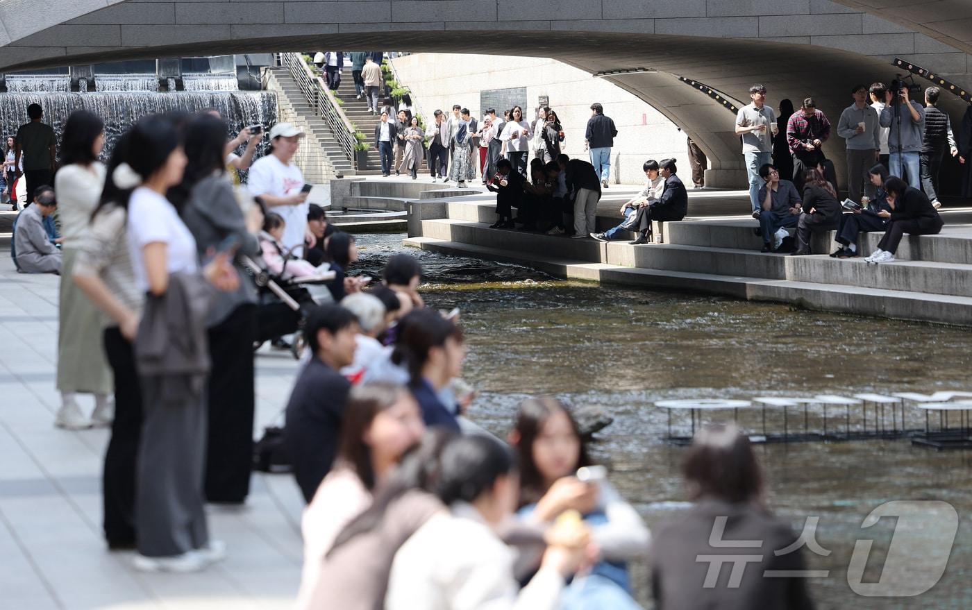 본문 이미지 - 서울 낮 최고 기온이 28도까지 오르는 등 초여름 날씨를 보인 14일 서울 중구 청계천을 찾은 시민들이 여유로운 시간을 보내고 있다. 2026.4.14 ⓒ 뉴스1 김성진 기자