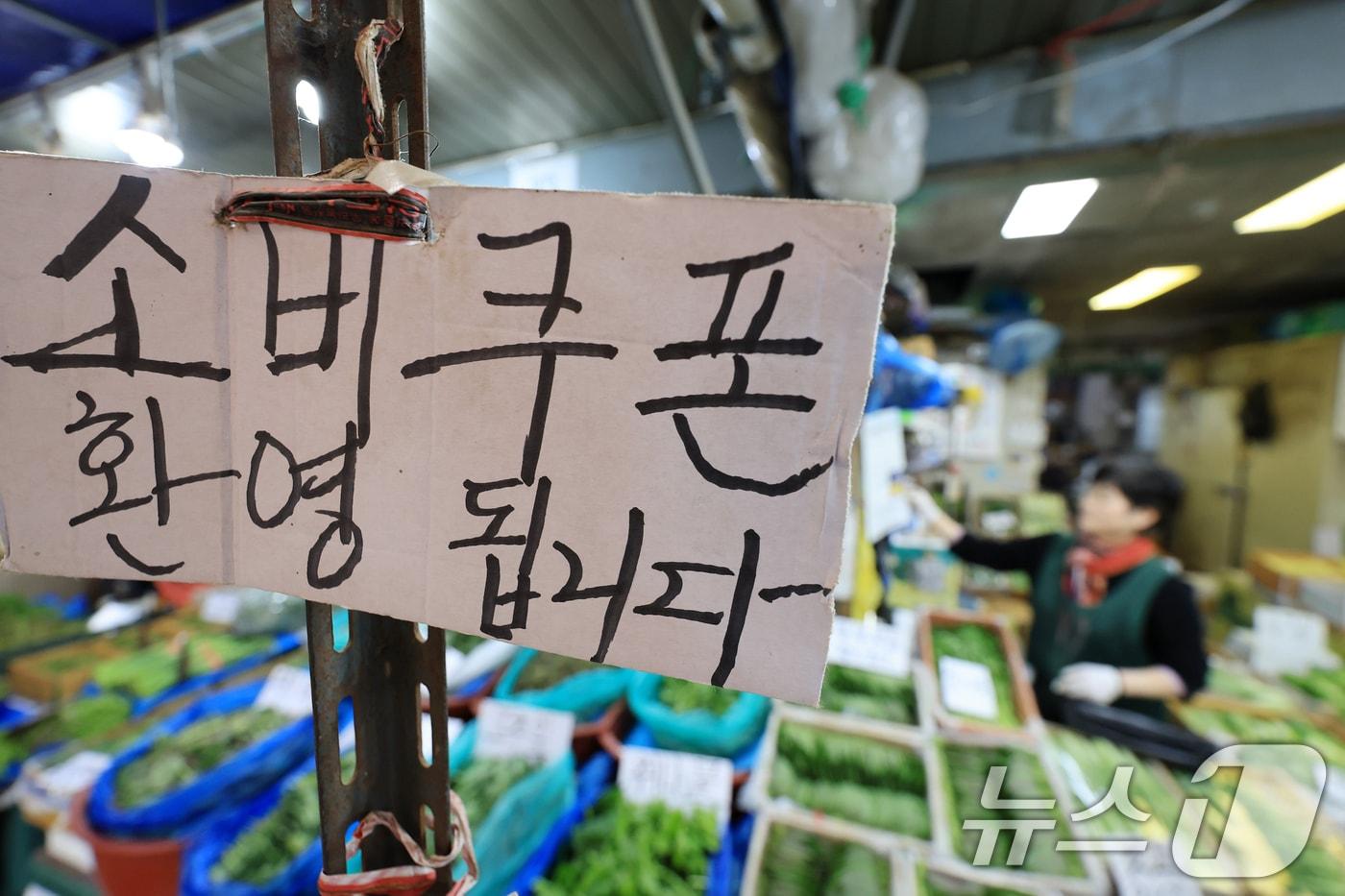 본문 이미지 - 정부가 중동 사태 장기화로 인한 고유가 피해 지원금을 70%의 국민에게 1인당 10만 원에서 최대 60만 원까지 오는 27일부터 차등 지급한다. 사진은 14일 서울 동대문구 경동시장 한 점포에 '민생회복 소비쿠폰 사용 가능' 안내문이 걸려있는 모습. 2026.4.14 ⓒ 뉴스1 이호윤 기자