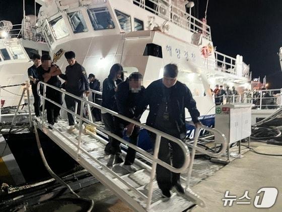 본문 이미지 - 밀입국 의심 선박을 검거해 승선원을 압송하는 해경(태안해경 제공. 재판매 및 DB금지) / 뉴스1