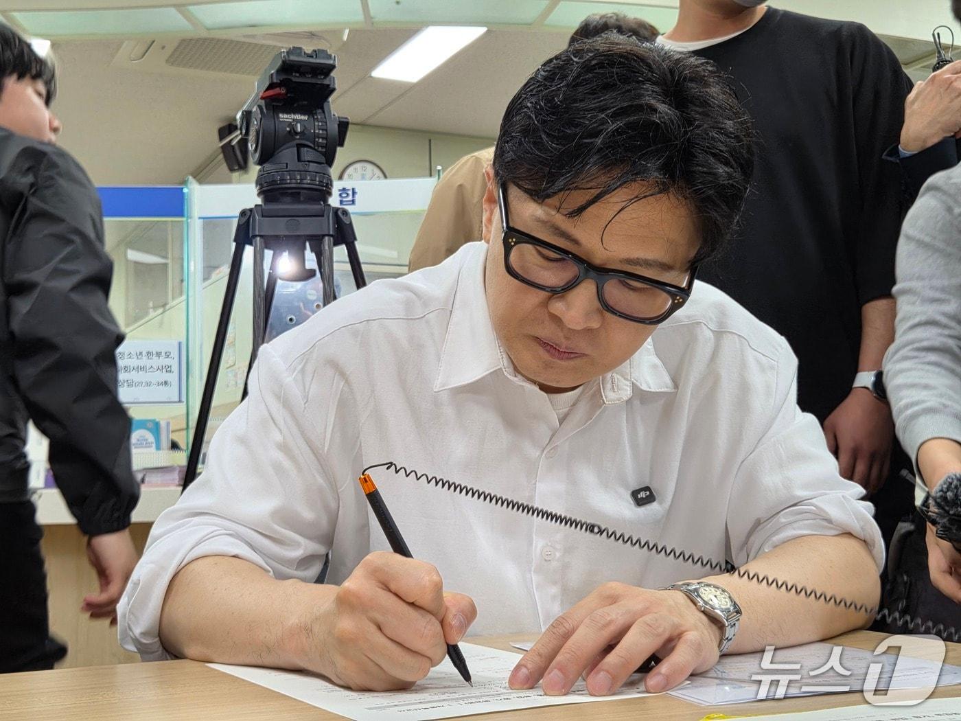 본문 이미지 - 한동훈 전 국민의힘 대표가 부산 북구 만덕2동 주민센터에서 전입신고서에 서명하고 있다.2026.4.14/뉴스1 ⓒ News1 임순택 기자